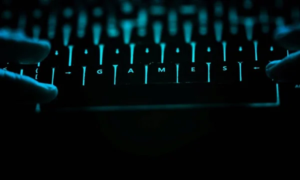 ゲーム - 夜照らされたコンピューターのキーボード上のテキスト. — ストック写真