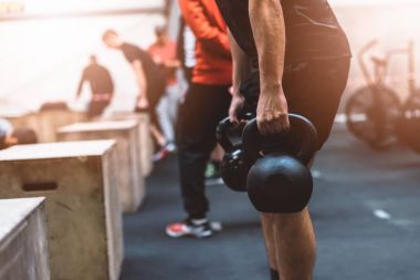 Fonksiyonel fitness salonunda Kettlebells ağırlık çekme adam