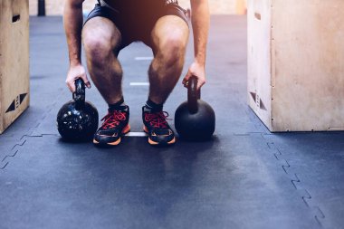 Fonksiyonel fitness salonunda Kettlebells ağırlık çekme adam