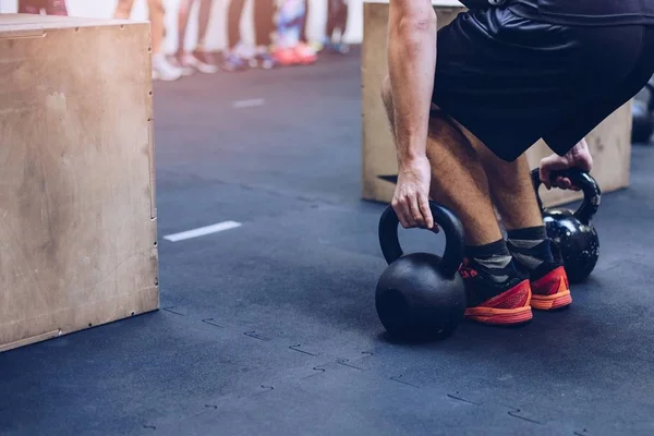 Homem puxando kettlebells pesos no ginásio de fitness funcional — Fotografia de Stock