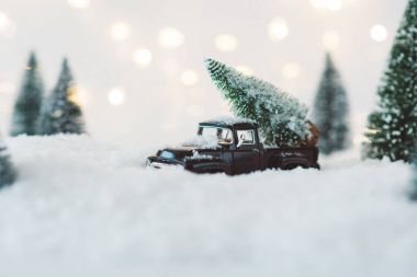 Noel ağacı taşıyan siyah oyuncak araba.