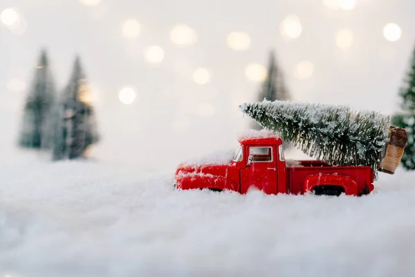Auto giocattolo rosso che trasporta albero di Natale . — Foto Stock
