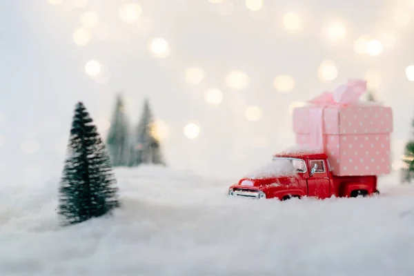 Coche de juguete rojo que lleva regalo de Navidad . — Foto de Stock