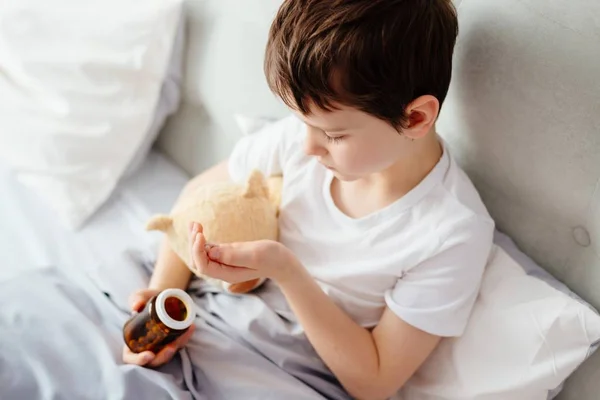 Niño tomando píldoras medicinales . — Foto de Stock