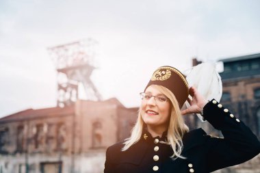 Beyaz tüy şapka ile da siyah kömür madenci foreman gala üniformalı kadın.