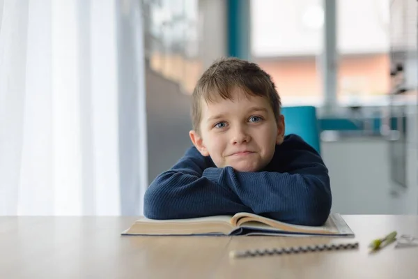 Felice ragazzo di 8 anni che fa i compiti a tavola — Foto Stock