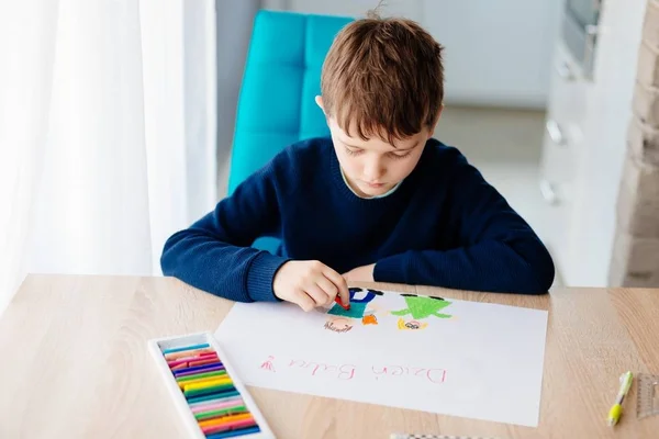 Glückliches polnisches Kind beim Zeichnen einer Grußkarte für seine Oma. — Stockfoto