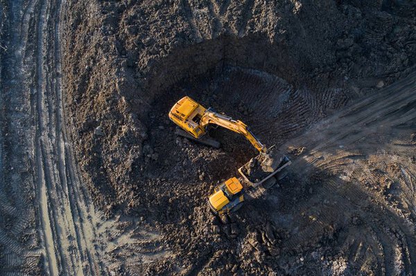 Aerial drone view of excavator loading the tipper truck