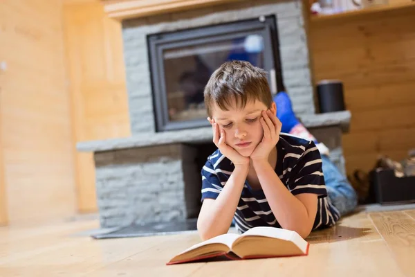 Eight years old boy reading a book — Stock Photo, Image