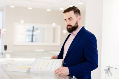 Alyans koleksiyonu gösterilen bir sakallı çekici adam