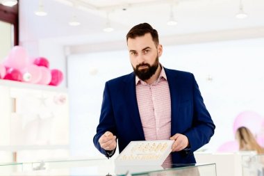 Alyans koleksiyonu gösterilen bir sakallı çekici adam