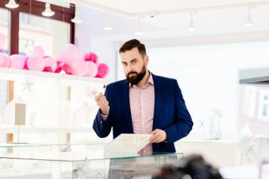 Alyans koleksiyonu gösterilen bir sakallı çekici adam