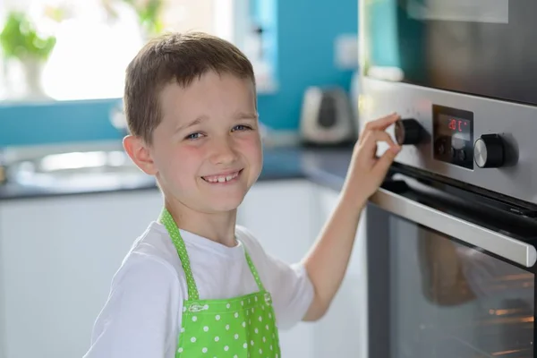 Kind jongen regulering van de temperatuur van de oven. — Stockfoto