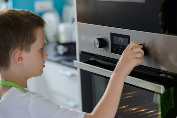 Niño regulando la temperatura del horno . —  Fotos de Stock