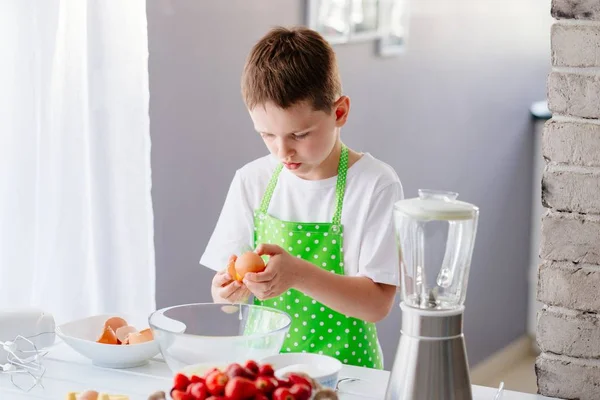 Junge knackt Ei und trennt Eigelb — Stockfoto