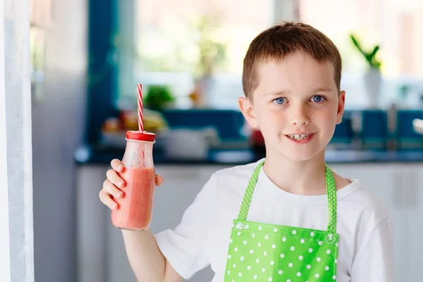 Child boy drinking strawberry smoothie — Stock Photo, Image