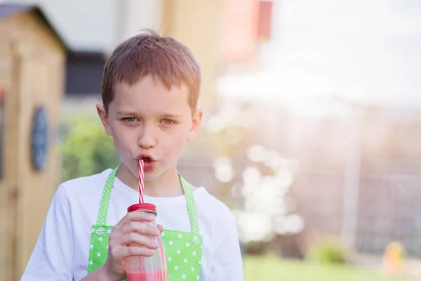 Barn pojke dricka jordgubbe smoothie — Stockfoto