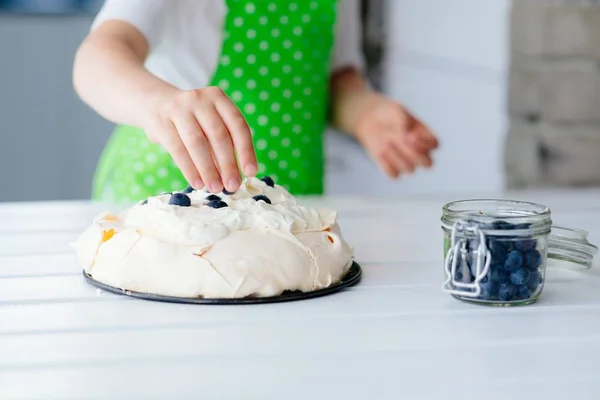 Feliz niño decorando merengue con arándanos — Foto de Stock