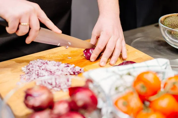 Köchin schneidet rote Zwiebel — Stockfoto