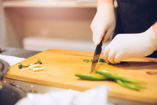 Kvinnan skära grönt kryddig peppar — Stockfoto