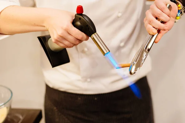 Kadın aşçı ısıtır tarçın daha fazla aroma elde etmek için — Stok fotoğraf