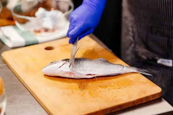 Mujer cocinera preparando y limpiando pescado crudo dorada —  Fotos de Stock