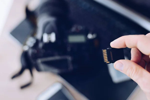 Mann hält Speicherkarte für DSLR-Kamera. — Stockfoto