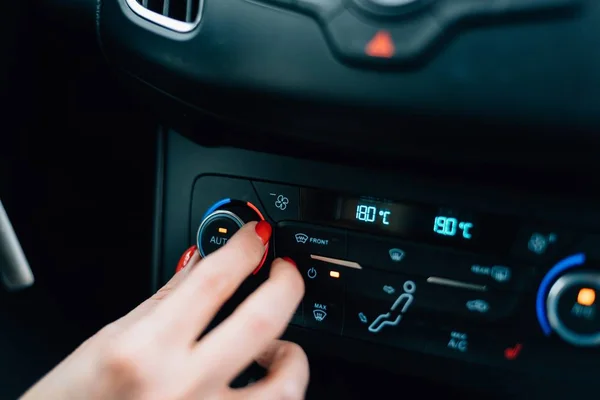 Donna che regola la temperatura dell'aria condizionata dell'auto . — Foto Stock