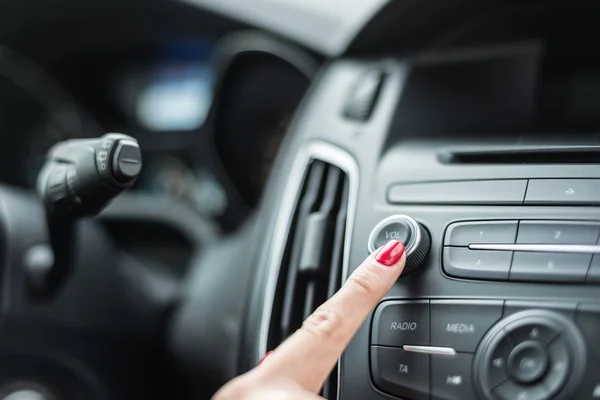 Mujer encendiendo la radio del coche — Foto de Stock