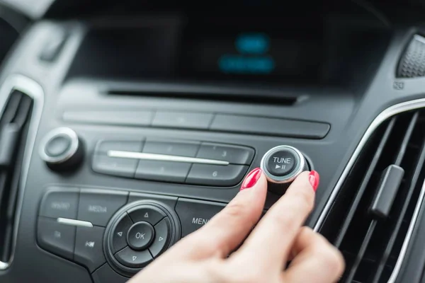 Mujer cambiando de frecuencia en la radio del coche — Foto de Stock