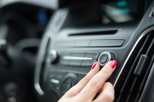 Mujer cambiando de frecuencia en la radio del coche — Foto de Stock