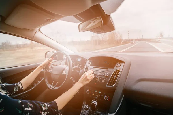 Young woman driving a car and adjusting car audio. — Stock Photo, Image