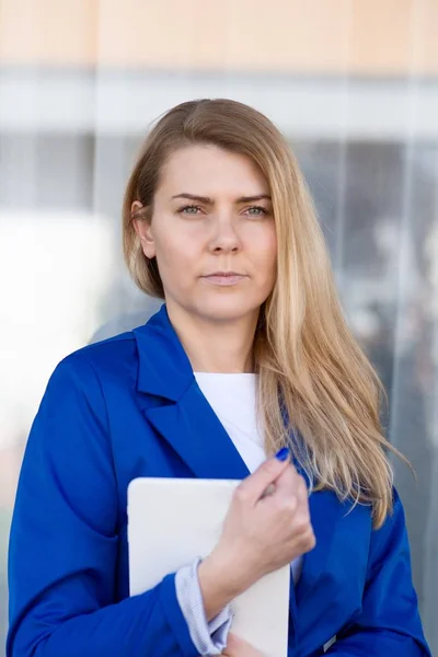 Unga eleganta affärskvinna i blå jacka håller tablett. — Stockfoto