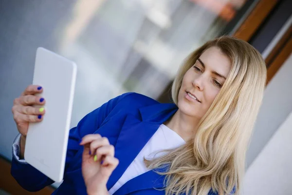 Young elegant business woman in blue jacket holding tablet. — Stock Photo, Image
