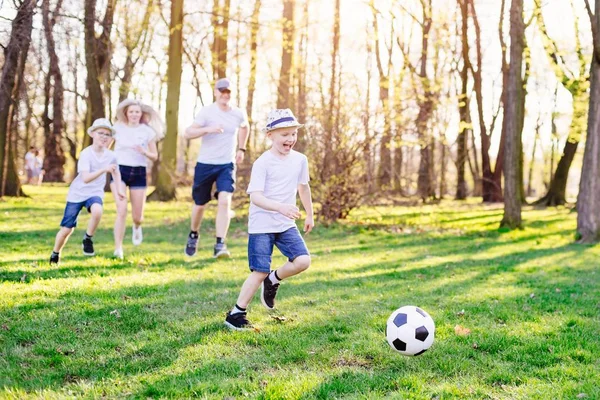 Familia jugando fútbol sobre hierba verde en el parque . —  Fotos de Stock