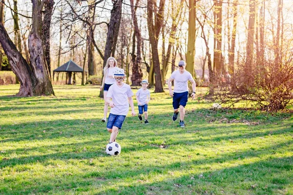 家庭在公园绿草上踢足球. — 图库照片