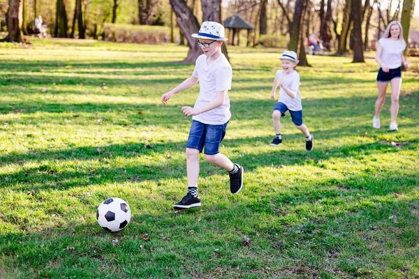 Семья играет в футбол на зеленой траве в парке . — стоковое фото