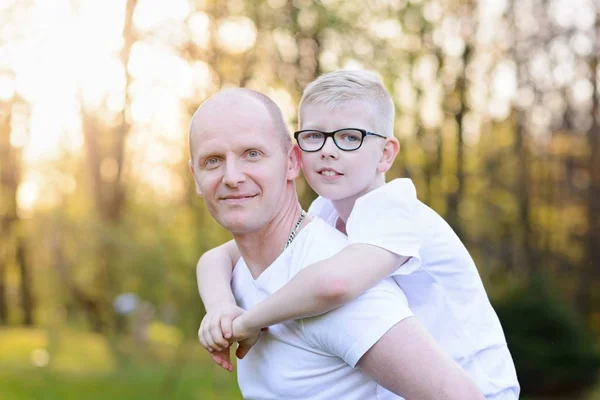 Happy young father carrying his son on back — Stock Photo, Image