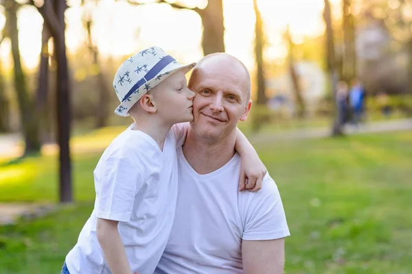 Happy child son kissing father