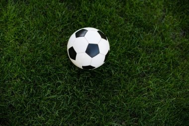 Yeşil çim üzerinde beyaz ve siyah futbol topu
