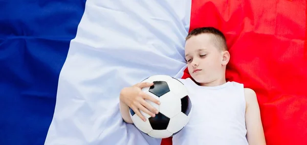 Disappointed France national football team. Child boy with football ball and French flag
