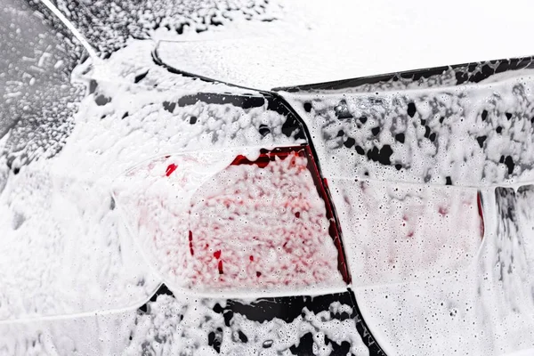Auto v myčce na auta pokryté aktivní pěnou — Stock fotografie
