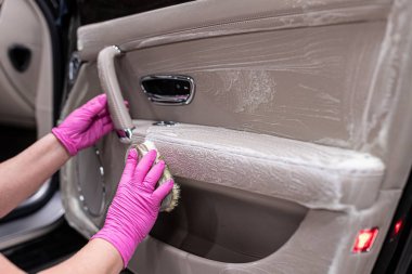 Cleaning car leather interior with brush. Car detailing