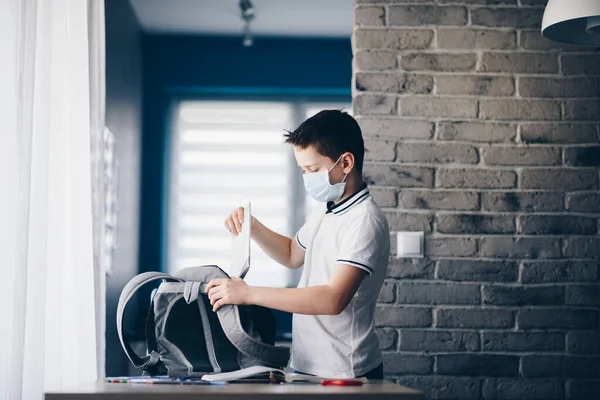 Quarantined bambino imballaggio suoi libri a scuola zaino . — Foto Stock