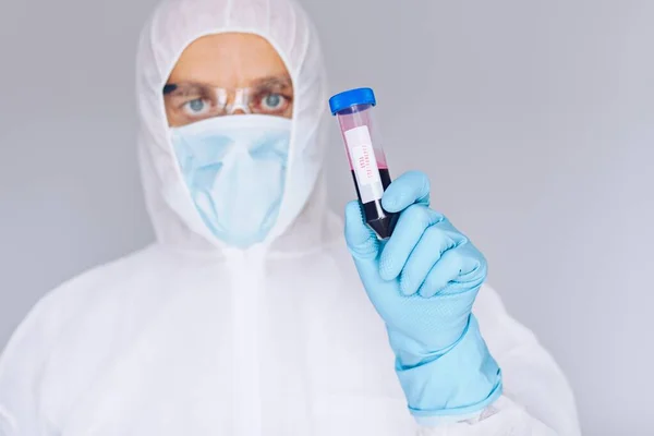 Wetenschapper in beschermende pak houden reageerbuis met bloed — Stockfoto