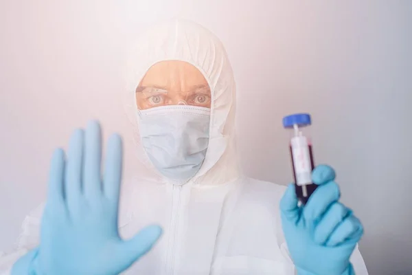 Wissenschaftler im Schutzanzug hält Reagenzglas mit Blut — Stockfoto