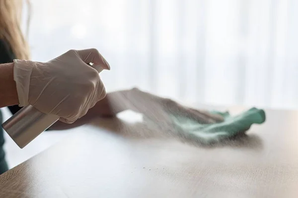 Woman disinfects table with spray disinfectant liquid — Stock Photo, Image