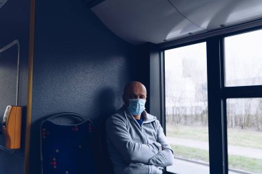 Otobüste koruyucu maskeli bir adam var. Toplu taşıma