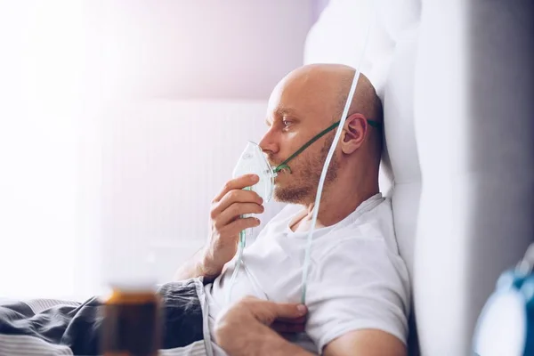 Людина дихає через кисневу маску в ліжку. Пацієнт Covid-19 . — стокове фото