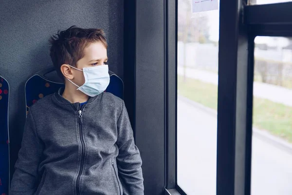 Junge mit medizinischer Schutzmaske in Linienbus. — Stockfoto